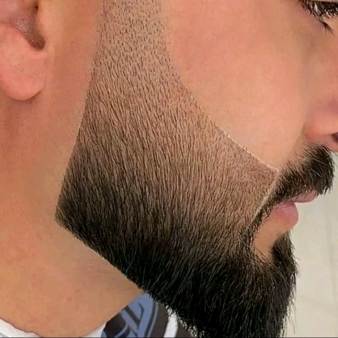 Close-up van een baard met een strak geschoren lijn op de wang